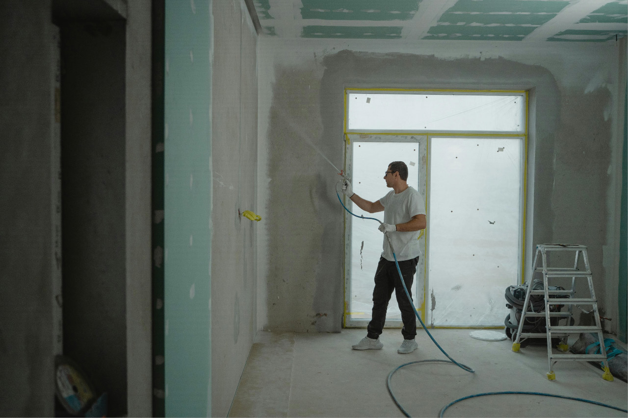 Equipe de construção executando reforma em ambiente residencial ou comercial com ferramentas e materiais organizados.
